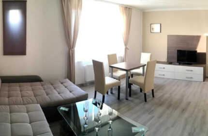 Hotel Residence Spalena apartment interior. Cheap gay-friendly Prague lodging. Living area with dining table, sofa, & TV. Gayborhood stay.