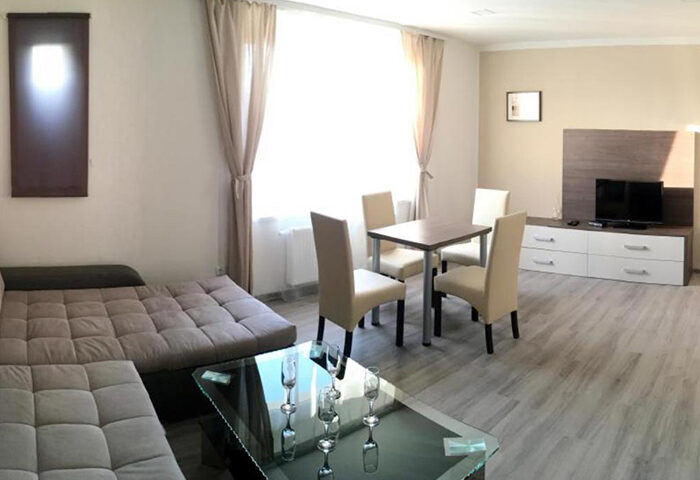 Hotel Residence Spalena apartment interior. Cheap gay-friendly Prague lodging. Living area with dining table, sofa, & TV. Gayborhood stay.