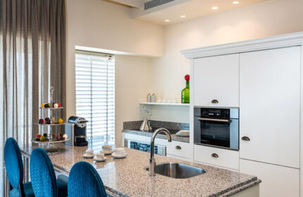 Herods Tel Aviv By The Beach kitchen. Cheap beachfront gay hotel with kitchen. Modern design, granite counter, blue chairs, & coffee maker.