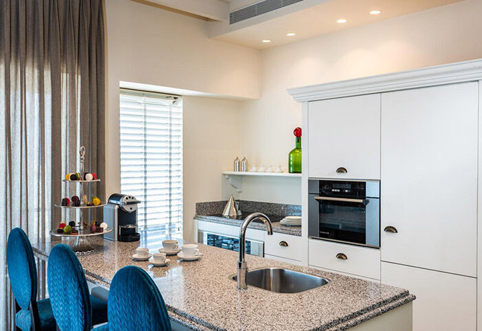 Herods Tel Aviv By The Beach kitchen. Cheap beachfront gay hotel with kitchen. Modern design, granite counter, blue chairs, & coffee maker.