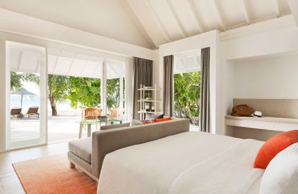 LUX* South Ari Atoll beachfront villa. Maldives gay resort room with beach view, deck chairs, and tropical trees. Cheap gay travel.