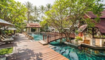 Chaweng Regent Beach Resort pool view. Gay hotel in Koh Samui, Thailand. Beachfront property with lush greenery and traditional Thai architecture.