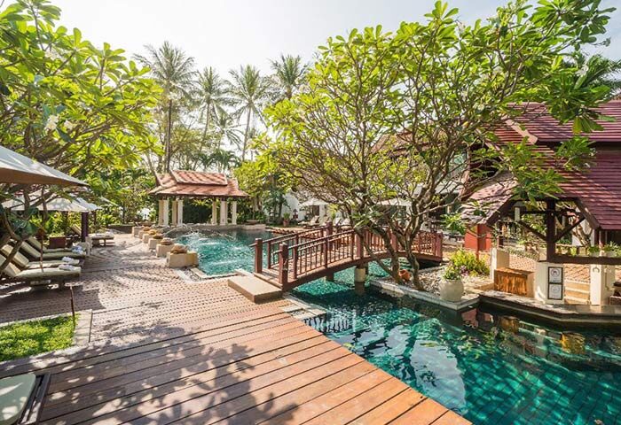 Chaweng Regent Beach Resort pool view. Gay hotel in Koh Samui, Thailand. Beachfront property with lush greenery and traditional Thai architecture.