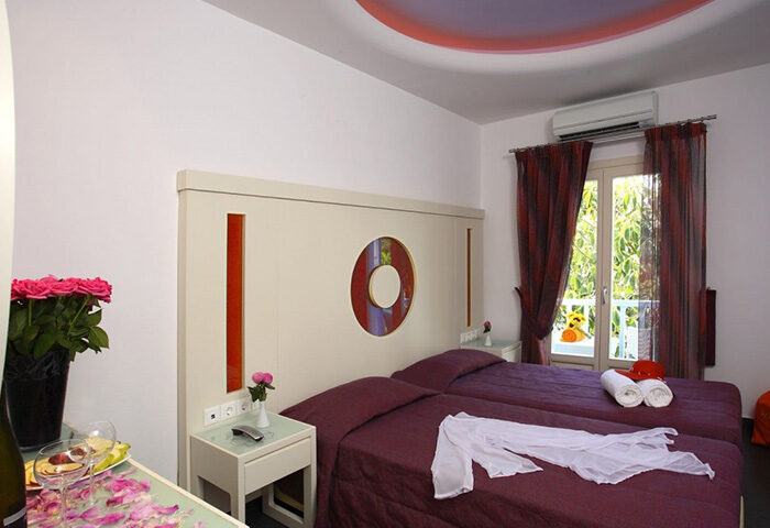 Matogianni Hotel, Mykonos. Budget gay hotel room in city center. Twin beds, flowers, balcony view. Perfect for gay travel in Mykonos.