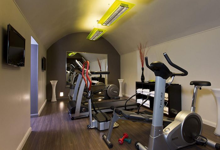 Duo Hotel Paris gym. Cheap city center gay hotel with fitness equipment, including treadmill, exercise bike, and weights for a workout.