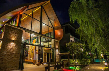 Hula Hula Resort Ao Nang, Krabi. Cool beach resort entrance at night. Gay-friendly hotel with modern design and lush landscaping. Cheap travel option.