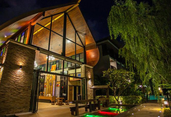 Hula Hula Resort Ao Nang, Krabi. Cool beach resort entrance at night. Gay-friendly hotel with modern design and lush landscaping. Cheap travel option.