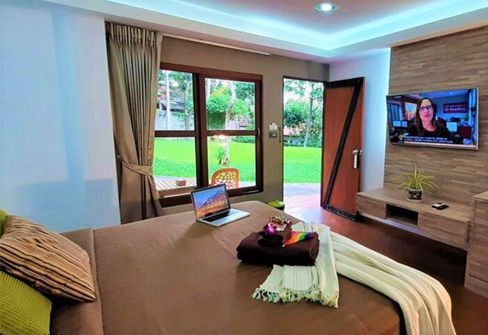 Alpha Gay Resort Koh Samui room. Gay men only adult hotel with bed, laptop, and TV. View of the garden. Cheap gay travel.