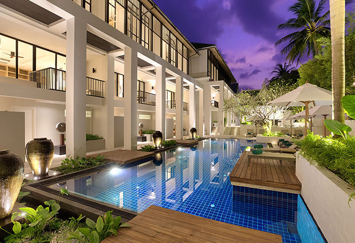 Outrigger Surin Beach Resort, Thailand, a gay-friendly beachfront hotel in Phuket. Pool view at dusk, ideal for big groups.