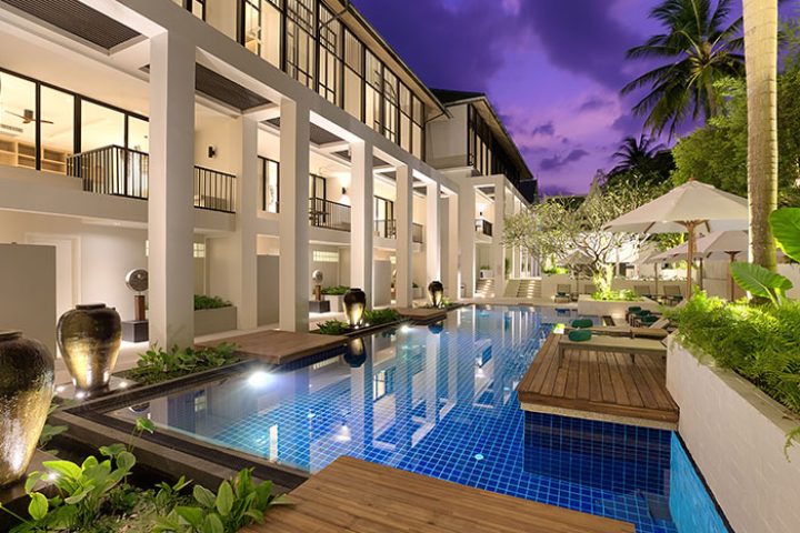 Outrigger Surin Beach Resort, Thailand, a gay-friendly beachfront hotel in Phuket. Pool view at dusk, ideal for big groups.