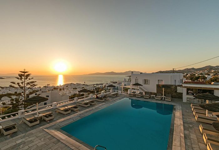 Hotel Alkyon rooftop pool at sunset. Gay-friendly hotel with ocean view. Cheap hotel option for gay travelers. Mykonos travel.