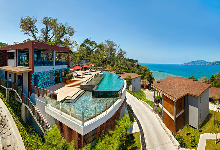 Amari Phuket beachfront hotel view. Gay honeymoon destination in Thailand with pool, lounge chairs, and ocean view.