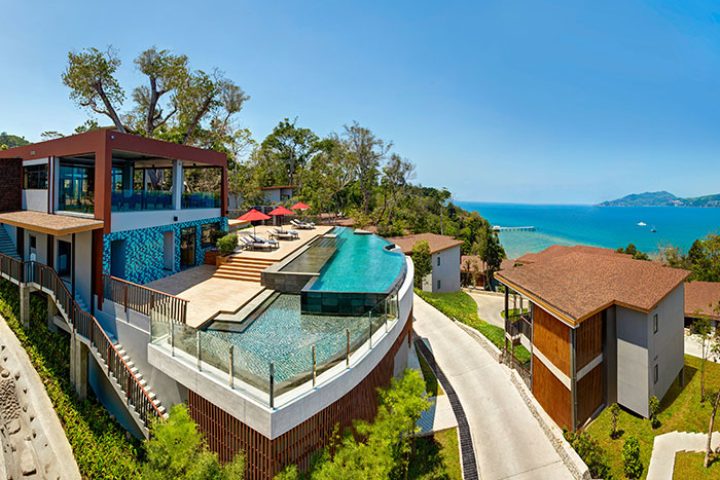 Amari Phuket beachfront hotel view. Gay honeymoon destination in Thailand with pool, lounge chairs, and ocean view.