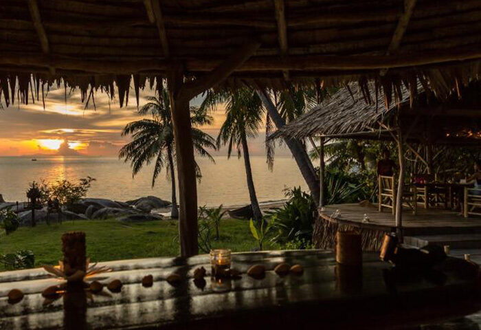 Koh Phangan's Somewhere Only We Know gay hotel. Sunset view from a cheap, tropical bungalow. Palm trees, ocean, and romantic ambiance.