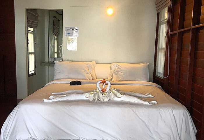 Tubtim Resort, Koh Samet. Room interior at this cheap gay hotel near gay nightlife. Bed with swan towel art and white linens.