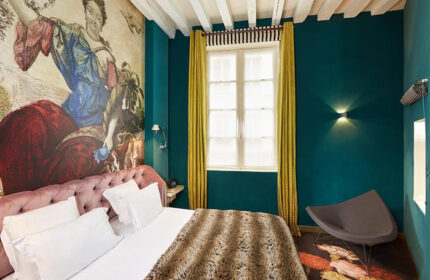 Hotel du Petit Moulin room. Gay-friendly Paris hotel in Le Marais. Luxurious bed, colorful decor, and unique design. Cheap gay hotel option.