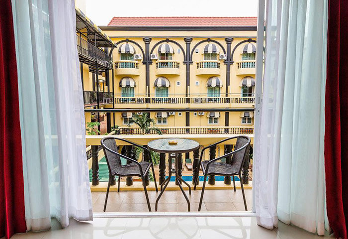 Balcony view at Zing Resort & Spa, a cheap gay hotel in Pattaya. Pool visible from balcony with table and chairs. Great for gay travel.