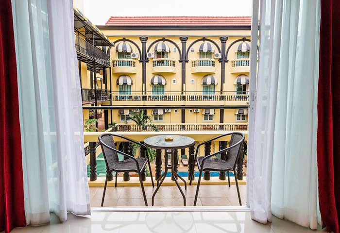 Balcony view at Zing Resort & Spa, a cheap gay hotel in Pattaya. Pool visible from balcony with table and chairs. Great for gay travel.