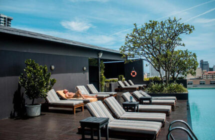 Page 10 Hotel rooftop pool in Pattaya. Man relaxing on sunbed. Gay hotel with city views. Cheap gay hotel in Thailand.