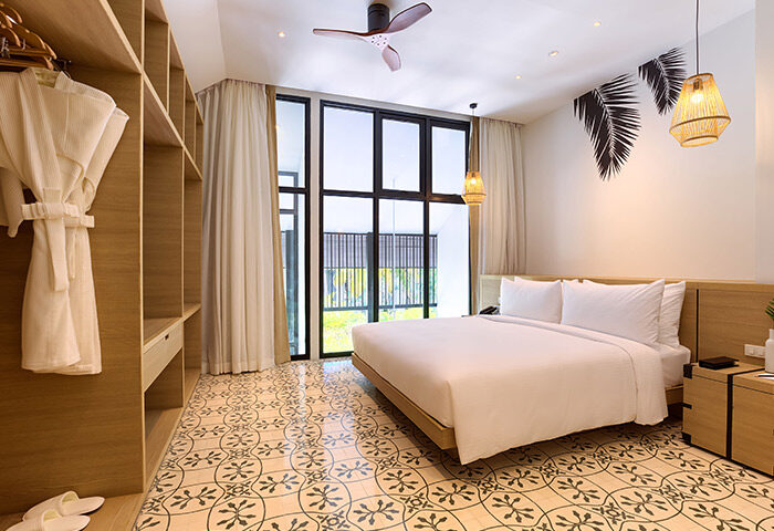 Outrigger Surin Beach Resort, Thailand. Cheap gay hotel beachfront room with king bed, closet, and tropical decor. Phuket gay travel advice.