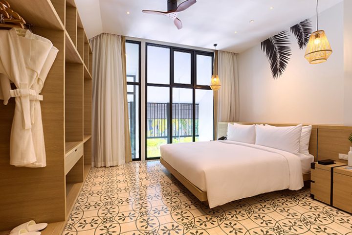 Outrigger Surin Beach Resort, Thailand. Cheap gay hotel beachfront room with king bed, closet, and tropical decor. Phuket gay travel advice.