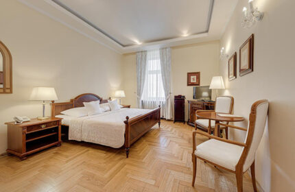 Louren Hotel, Prague: A cheap gay hotel near Vinohrady gay nightlife. Bedroom with double bed, table, chairs, and parquet flooring.