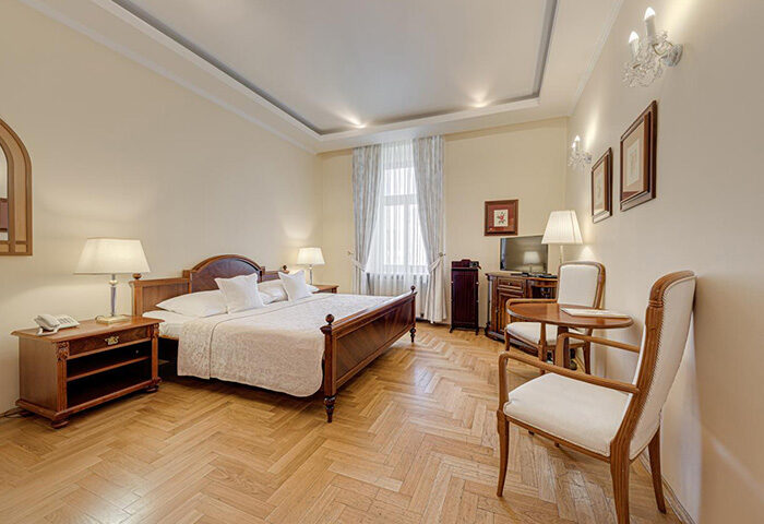 Louren Hotel, Prague: A cheap gay hotel near Vinohrady gay nightlife. Bedroom with double bed, table, chairs, and parquet flooring.