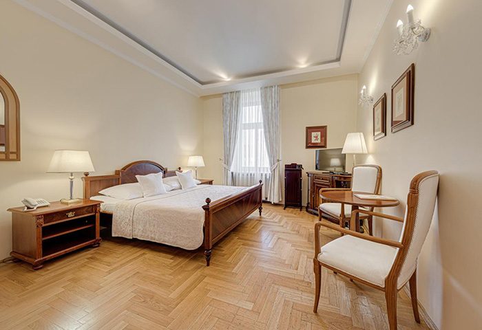 Louren Hotel, Prague: A cheap gay hotel near Vinohrady gay nightlife. Bedroom with double bed, table, chairs, and parquet flooring.