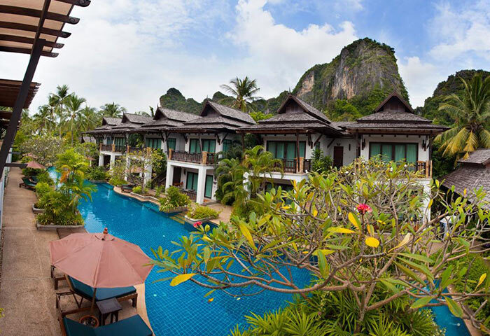 Railay Village Resort pool view. Gay-friendly hotel in Railey, Krabi. Lush tropical landscape, Thai architecture, and inviting blue pool.