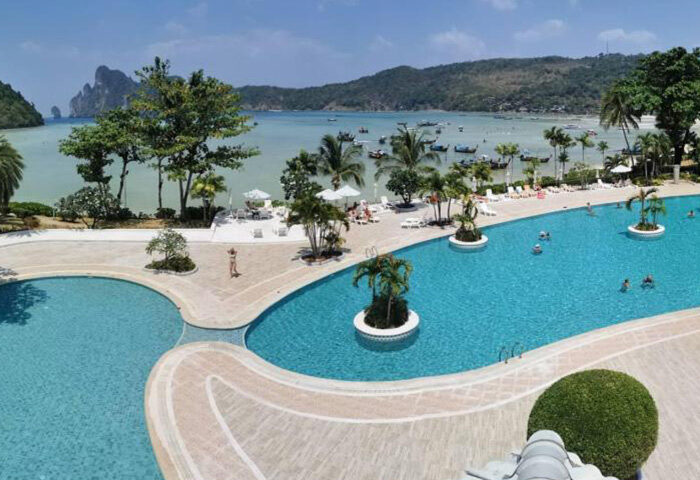 Phi Phi Island Cabana Hotel pool view. Gay travel in Ton Sai, Thailand. Cheap hotel with ocean view and island landscape. Palm trees.