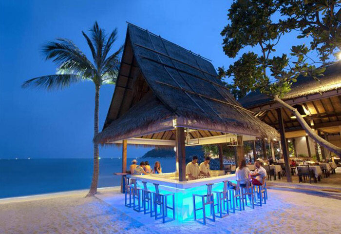 Buri Rasa Koh Phangan beachfront bar at night. Gay-friendly hotel with pool, beach, and restaurant. Tropical island travel.