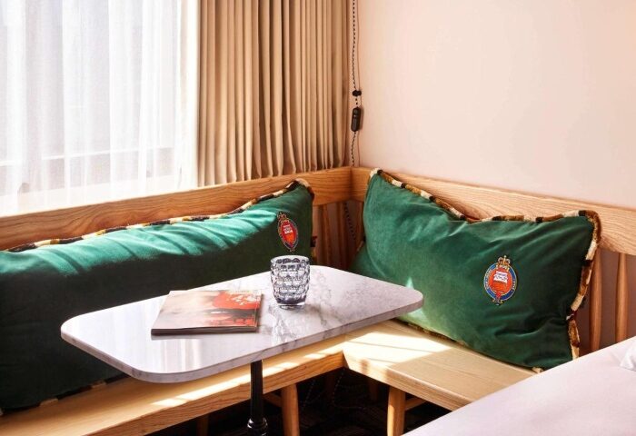 Mama Shelter Shoreditch detail. Corner seating area with green cushions, marble table, and magazine. Gay friendly hotels in London.