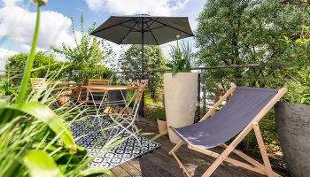 Mosaic House Design Hotel's rooftop garden in Prague's Old Town. Cheap gay hotels with city center views, table, chair, and umbrella.