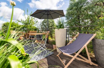 Mosaic House Design Hotel's rooftop garden in Prague's Old Town. Cheap gay hotels with city center views, table, chair, and umbrella.