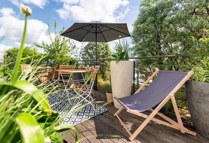 Mosaic House Design Hotel's rooftop garden in Prague's Old Town. Cheap gay hotels with city center views, table, chair, and umbrella.