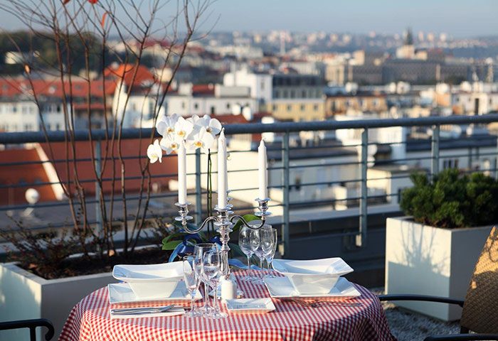 Ibis Praha Old Town Hotel's rooftop bar: A romantic table is set with a view of Prague. Perfect for gay travelers in Prague.