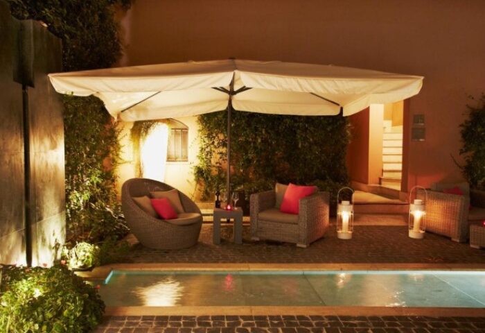 Hotel Indigo Rome St. George outdoor lounge area at night. Gay-friendly hotel with seating, pool, and ambient lighting near gay saunas in Rome.