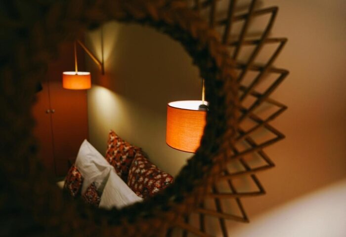 Rambutan Resort Siem Reap room detail. Mirror view of pillows and lamps. Cheap gay hotels in Siem Reap city center for gay travel.
