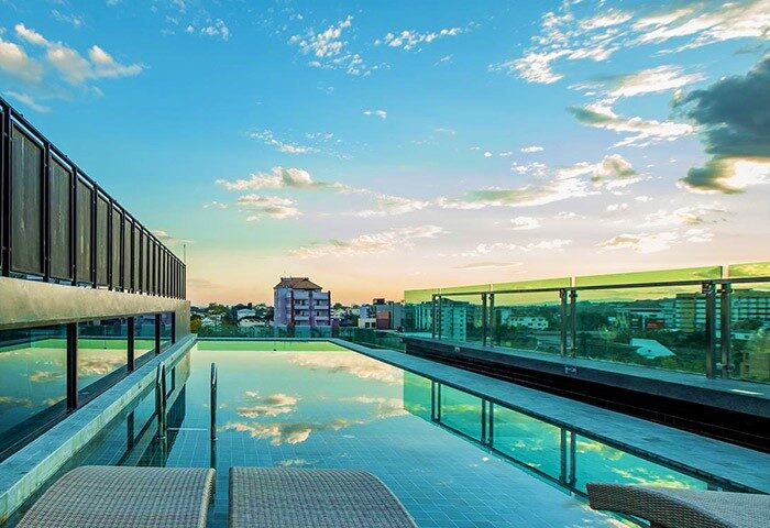 Rooftop pool at Art Mai Gallery Nimman Hotel in Chiang Mai. A cheap, gay-friendly luxury hotel with city views at sunset.