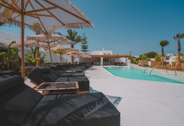 Akkadian Gay Only Hotel Mykonos outdoor pool view. Cheap gay hotels in Mykonos with sunbeds & umbrellas for gay men travelers.