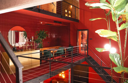 Stories Hotel Budapest: Interior view of a cheap hotel with big rooms for 6 people. Red decor, plants, and stylish design. Gay-friendly.