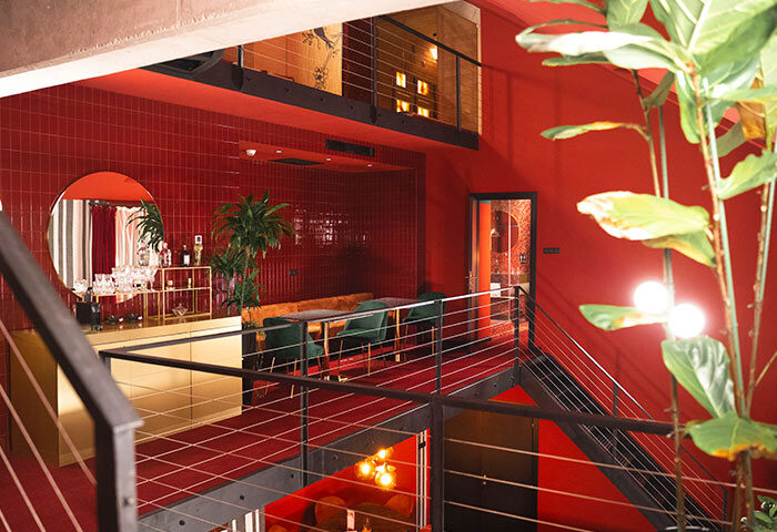 Stories Hotel Budapest: Interior view of a cheap hotel with big rooms for 6 people. Red decor, plants, and stylish design. Gay-friendly.