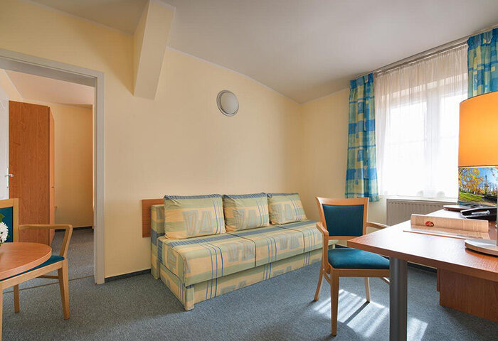 EA Hotel Tosca living room near Prague's gayborhood Vinohrady. Cheap hotel with sofa, desk, and chairs. Perfect for gay travelers.
