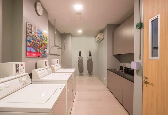 Holiday Inn Express Sathorn Bangkok laundry room. Washers, ironing boards, sink, and cabinets. LGBT friendly city hotel.