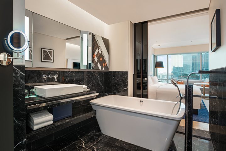 Le Méridien Bangkok hotel bathroom. Luxury bathtub, marble surfaces, and view into the bedroom. Gay-friendly hotel in Bangkok's gay area.