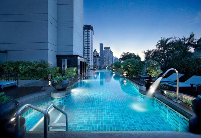 Banyan Tree Bangkok rooftop pool at dusk. A luxury gay hotel in Bangkok, Thailand. Perfect for gay men's travel and vacations.