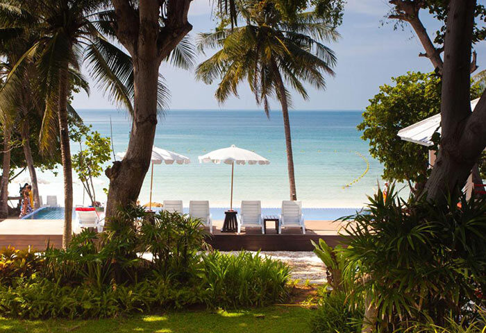 Lima Coco Resort, a cheap luxury gay hotel in Koh Samet. Beachfront swimming pool with lounge chairs and umbrellas. Tropical paradise.