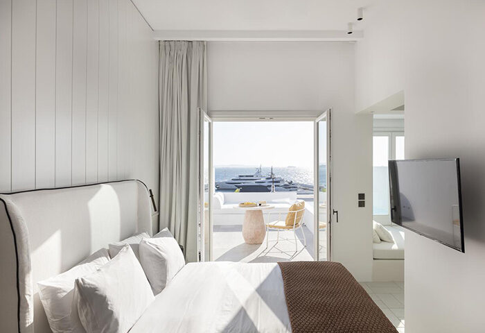 Porto Mykonos Hotel: Luxury gay hotel room with private balcony view of Mykonos Town. Cheap luxury gay travel destination.