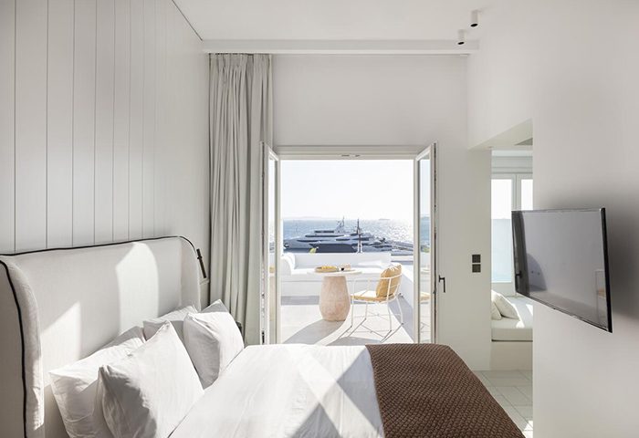 Porto Mykonos Hotel: Luxury gay hotel room with private balcony view of Mykonos Town. Cheap luxury gay travel destination.
