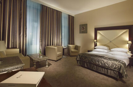 Grandior Hotel Prague room. Cheap luxury gay hotel in Prague Old Town. Room with double bed, chairs, and curtains.